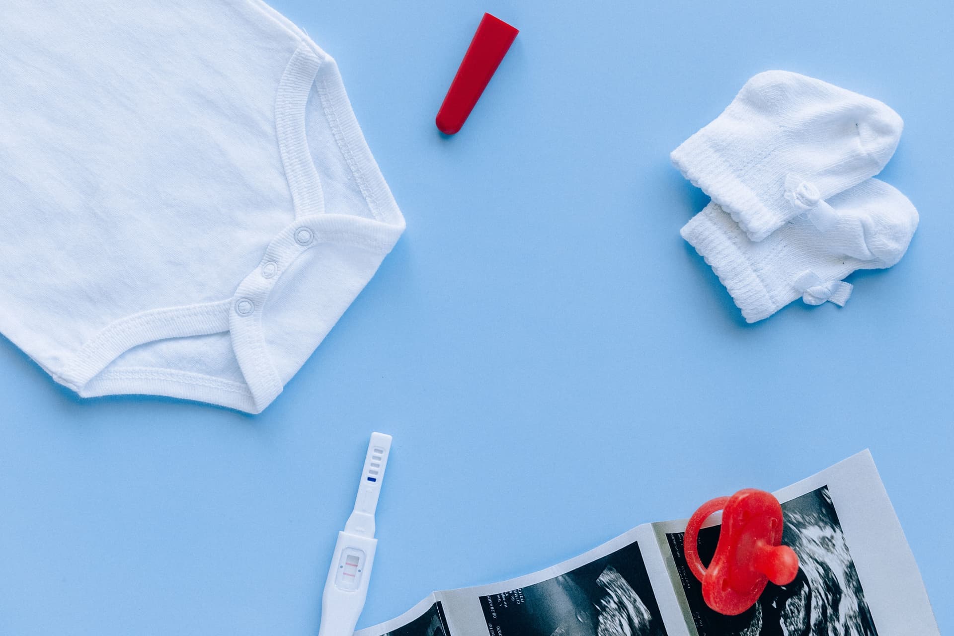 A flat lay of baby essentials arranged on a blue background (illustrative photo)